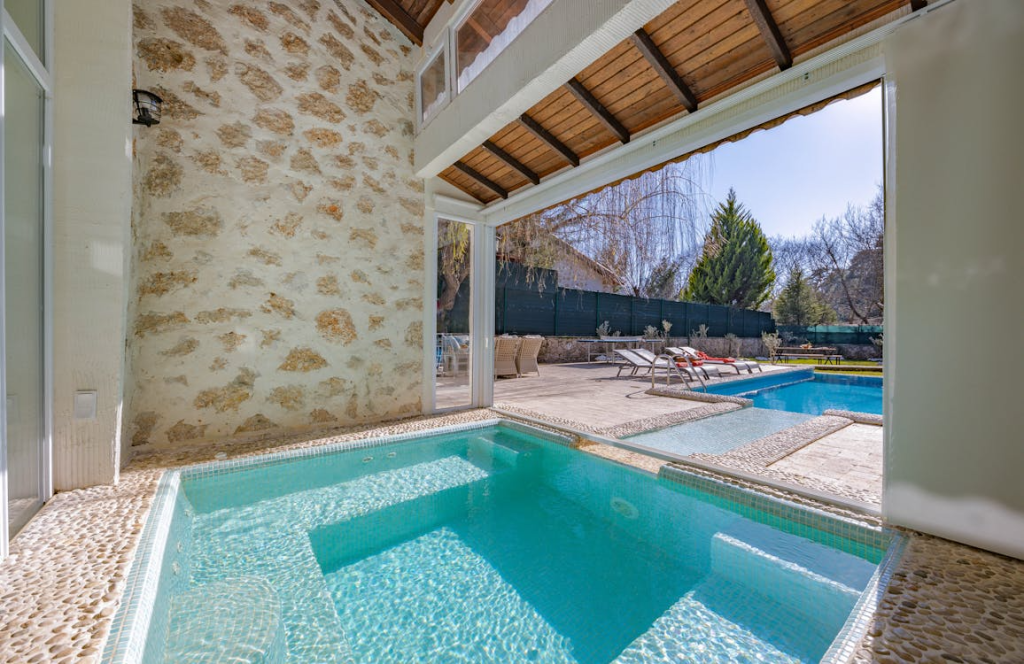 two connected pools, one in a backyard, outdoor space, the other partially indoors.