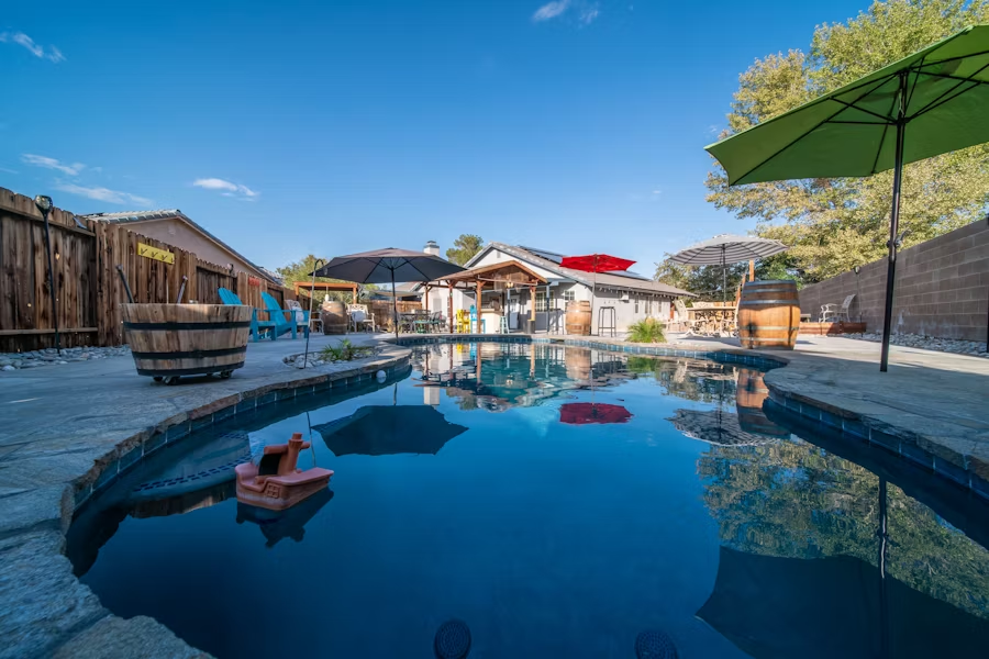 An empty swimming pool with an umbrella over it.