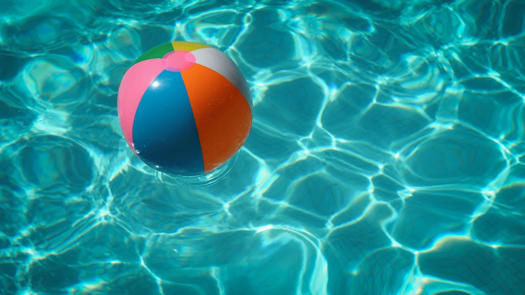 A multicolored beach ball in a pool.